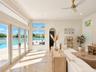 Large-format windows, multi-panel glass patio doors, recessed lighting, arched entryway, and stone-finish flooring