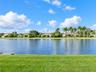Waterfront setting with a manicured lawn and mature palm trees