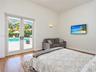 Full-height glass French doors featuring matte black hardware, wood-finish flooring, and a wall-mounted light fixture