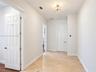 Hallway featuring diagonal-set tile flooring, multi-panel doors, and a decorative drum-style ceiling light fixture