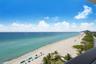 Elevated balcony featuring an expansive ocean panorama, sandy shoreline, and tropical vegetation