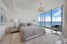 Floor-to-ceiling windows, polished stone flooring, recessed ceiling lighting, and a crystal drum chandelier
