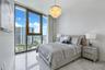 Floor-to-ceiling windows, polished stone flooring, and tiered crystal chandelier fixture
