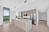 Neutral-toned interior space featuring light wood-finish flooring, white walls, and two sets of white louvered-style closet doors