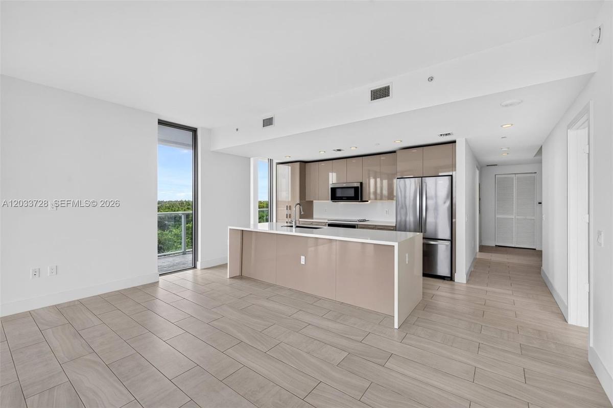 Neutral interior space featuring wood-finish tile flooring, recessed ceiling lighting, and floor-to-ceiling louvered bi-fold closet doors