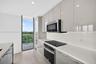 Neutral-toned tile flooring, dual floor-to-ceiling sliding glass doors, and recessed ceiling lighting