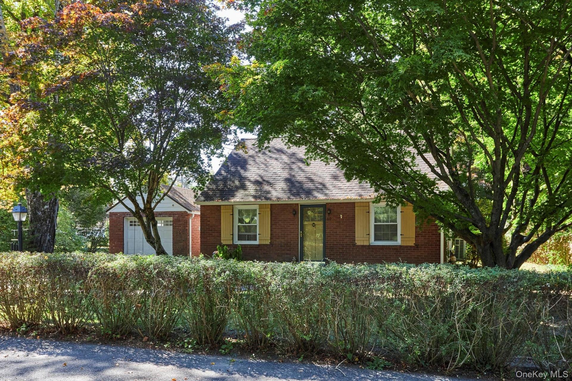 View of front facade with brick siding and a shingled roof
