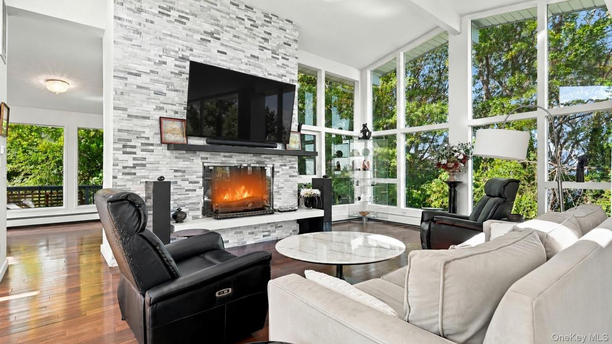 Living Room featuring wood-burning fireplace with stone surround