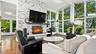 Living Room featuring wood-burning fireplace with stone surround