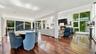 Open-concept interior featuring hardwood flooring, floor-to-ceiling windows, recessed lighting, and a floor-to-ceiling stone-veneer fireplace