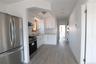 Kitchen featuring stainless steel refrigerator and range, white cabinetry, solid-surface countertops, and wood-finish flooring