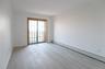 Interior room featuring wood-finish flooring, recessed ceiling lighting, and a sliding glass door with a wood-trim frame
