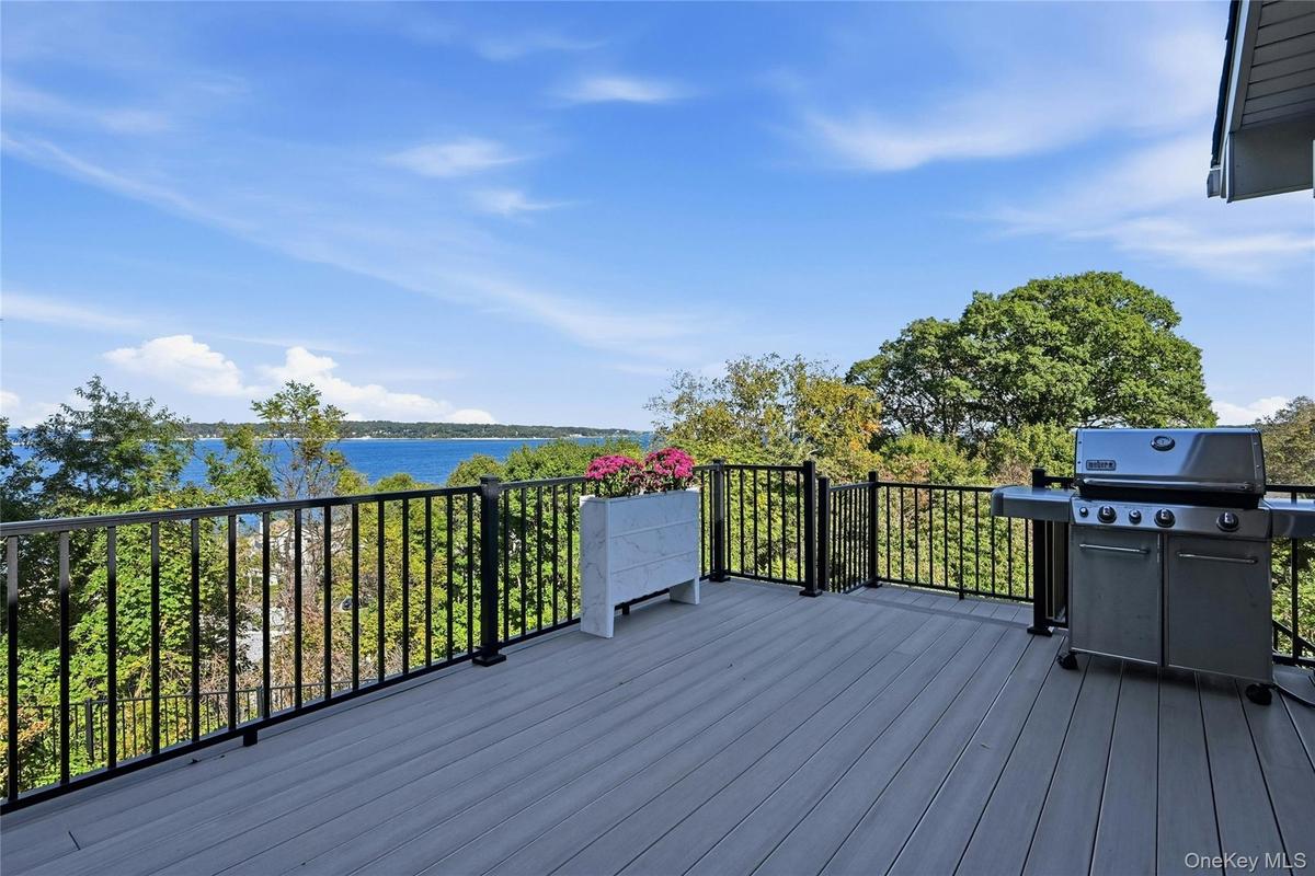 The expansive elevated deck features low-maintenance composite decking and offers breathtaking water views, creating an inviting setting for outdoor r
