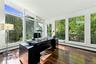 Home office featuring expansive floor-to-ceiling windows, hardwood flooring, and private deck