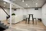 Finished basement featuring light wood-style floors and radiator heating unit