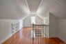 Additional living space with wood walls, light wood finished floors, and vaulted ceiling
