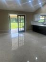 Tiled flooring, vaulted ceiling with wood-plank finish, recessed lighting, glass-paned French doors, and cabinetry with contrasting countertops