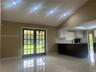 Vaulted ceiling with shiplap detailing, recessed lighting, tile flooring, glass-paneled double doors, and two-tone cabinetry with solid-surface counte