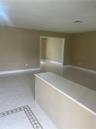 Neutral-toned interior featuring large-format diagonal tile flooring with decorative inlaid border and an integrated solid-surface countertop
