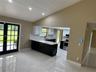 Kitchen featuring two-tone cabinetry, quartz countertops, tile flooring, vaulted ceiling with recessed lighting, and French doors