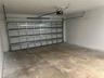 Two-car garage featuring a sectional metal door, an automatic belt-drive opener, and finished concrete flooring