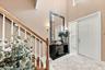 Foyer featuring a double-height ceiling, staircase with wood handrails and white balusters, multi-panel entry door with sidelight, tile flooring, and 