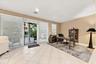 Neutral-toned interior featuring large-format tile flooring, recessed lighting, and expansive sliding glass doors with horizontal blinds, providing ac