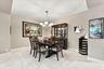 Dining area featuring large-format diagonal tile flooring, a multi-arm chandelier with glass shades, and neutral wall tones