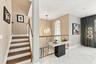 Staircase featuring wood-finish treads, white risers, and a wood handrail with white balusters