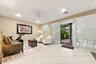 Large-format tile flooring, recessed lighting, ceiling fan, and sliding glass doors with horizontal blinds