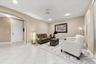 Interior space featuring ceramic tile flooring, arched wall detailing, recessed lighting, and windows with horizontal blinds