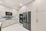 Kitchen featuring flat-panel cabinetry, stainless steel wall-mounted oven and microwave, stainless steel French-door refrigerator, integrated cooktop,