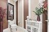 Restroom featuring two-tone striped wall detailing, ceramic tile flooring, and a standard-profile toilet