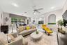 Open-concept interior featuring recessed lighting, a ceiling fan, a kitchen island with stone countertops, white flat-panel cabinetry, and an arched w