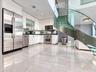 Spiral staircase featuring glass treads and stainless steel railings, double-height ceilings, polished tile flooring, floor-to-ceiling windows, and fr