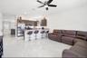 Open concept interior featuring polished tile flooring, dark wood-finish cabinetry, stainless steel appliances, a peninsula with stone-finish countert