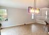 Tile flooring, multi-light rectangular pendant fixture, grid-pattern windows, and staircase with white railings