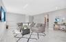 Open-concept living space featuring high-gloss tile flooring, recessed lighting, and neutral wall tones