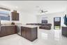 Kitchen featuring dark-finish cabinetry, neutral-toned countertops, stainless steel dishwasher, polished tile flooring, and a ceiling fan