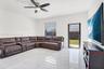 Polished large-format tile flooring, ceiling fan with integrated lighting, and a glass-paneled exterior door