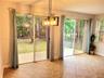 Dual glass sliding doors, ceramic tile flooring, geometric metal pendant lighting, and access to a concrete patio
