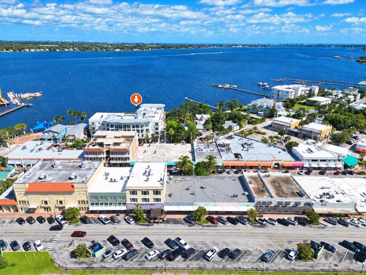 Aerial perspective of waterfront property featuring multi-story building architecture, direct proximity to open water, and localized street-level park