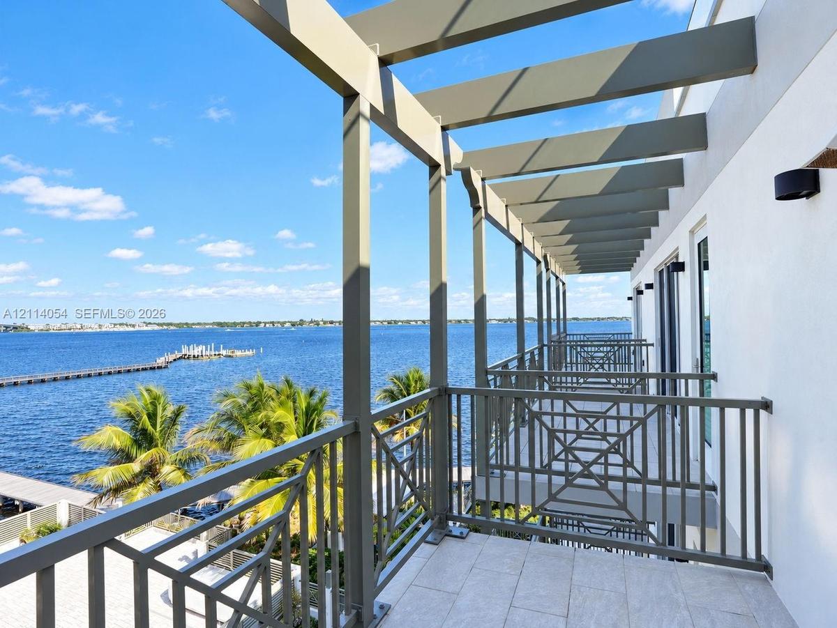 Covered balcony featuring a structural pergola, geometric metal railings, and tile flooring