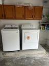 Laundry space featuring wall-mounted wood cabinetry and built-in metal wire shelving