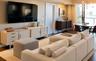 Living area featuring wood-finish flooring, recessed ceiling lighting, a swinging interior door, and a multi-bulb overhead light fixture