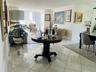 Polished tile flooring, expansive floor-to-ceiling windows, and white shaker-style kitchen cabinetry