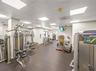 Fitness room featuring a drop ceiling with integrated recessed lighting and durable flooring