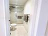 Bathroom featuring a shower stall with a glass sliding door, white tile wall surfacing, ceramic tile flooring, and a chrome-finish shower fixture