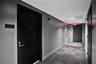 Hallway featuring dark solid-core doors, neutral wall finish, and patterned commercial-grade carpeting
