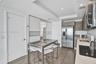 Kitchen featuring horizontal wood-grain cabinetry, stainless steel side-by-side refrigerator, recessed lighting, wood-finish flooring, and solid-surfa